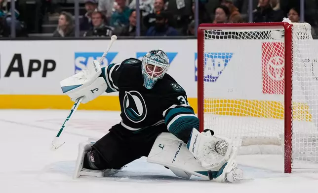San Jose Sharks goaltender Alex Nedeljkovic deflects a shot during the second period of an NHL hockey game against the Carolina Hurricanes, Tuesday, Oct. 14, 2025, in San Jose, Calif. (AP Photo/Godofredo A. Vásquez)