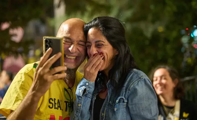 Einav Zangauker, center, mother of Matan Zangauker, who is being held hostage by Hamas, reacts along with other families and supporters of Israeli hostages after the announcement that Israel and Hamas have agreed to the first phase of a peace plan, as they gather at a plaza known as the hostages square in Tel Aviv, Israel, Thursday, Oct. 9, 2025. (AP Photo/Ohad Zwigenberg)