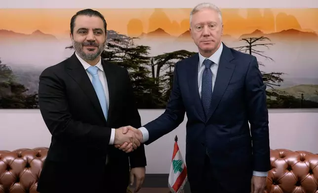 Lebanese Foreign Minister Youssef Rajji, right, shakes hands with his Syrian counterpart Asaad al-Shibani before their meeting in Beirut, Lebanon, Friday, Oct. 10, 2025. (AP Photo/Hassan Ammar)