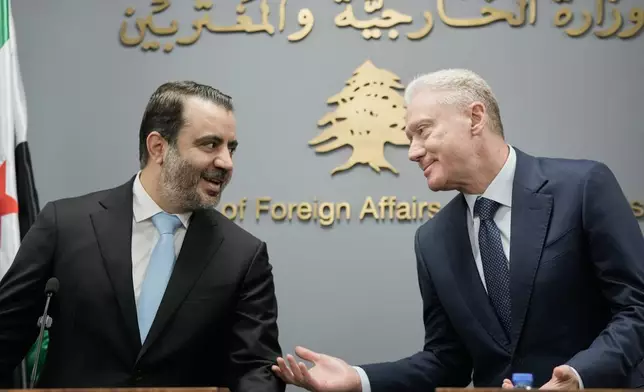 Syrian Foreign Minister Asaad al-Shibani, left, speaks with Lebanese Foreign Minister Youssef Rajji, right, before a briefing for journalists following their meeting in Beirut, Lebanon, Friday, Oct. 10, 2025. (AP Photo/Hassan Ammar)
