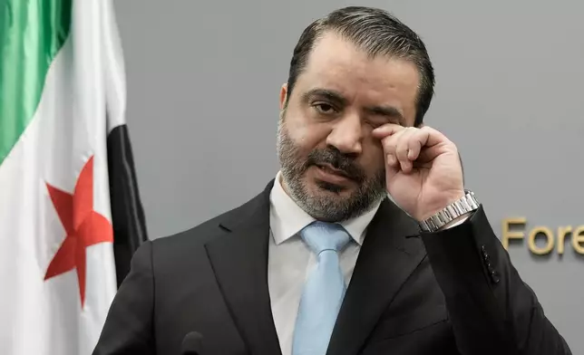 Syrian Foreign Minister Asaad al-Shibani wipes his eye as he speaks during a briefing for journalists following his meeting with Lebanese Foreign Minister Youssef Rajji, in Beirut, Lebanon, Friday, Oct. 10, 2025. (AP Photo/Hassan Ammar)