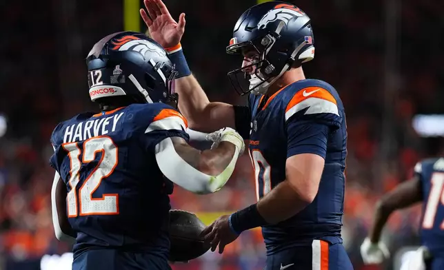 Denver Broncos quarterback Bo Nix, right, celebrates after Denver Broncos running back RJ Harvey (12) scored a touchdown against the Cincinnati Bengals during the second half of an NFL football game Monday, Sept. 29, 2025, in Denver. (AP Photo/Jack Dempsey)