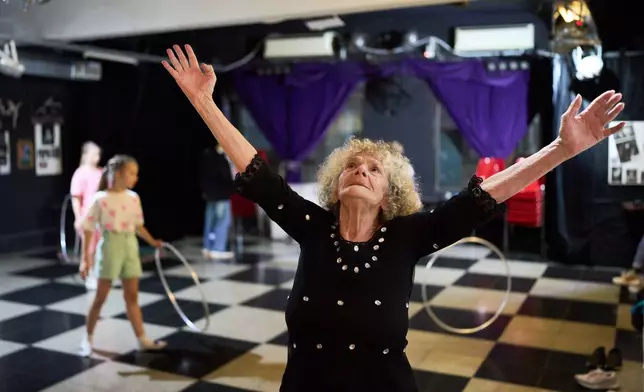 Retiree Delia Donn, 78, a regular at weekly protests outside Congress calling for better pensions, dances at the cultural center "El Donn," which she helps her son run in memory of her late brother, a renowned classical dancer, in Buenos Aires, Argentina, Friday, Sept. 26, 2025. (AP Photo/Rodrigo Abd)
