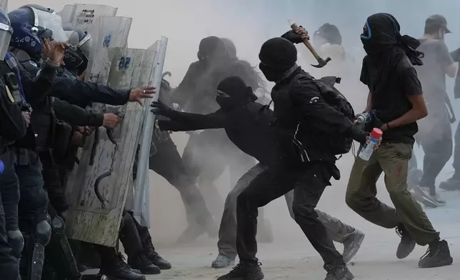 Demonstrators and riot police face off during a protest commemorating the anniversary of the 1968 Tlatelolco killings, when soldiers fired on student protesters, in Mexico City, Thursday, Oct. 2, 2025. (AP Photo/Claudia Rosel)