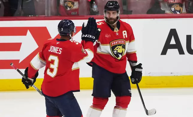 Florida Panthers defenseman Aaron Ekblad (5) celebrates his goal with defenseman Seth Jones (3) during the second period of an NHL hockey game against the Ottawa Senators, Saturday, Oct. 11, 2025, in Sunrise, Fla. (AP Photo/Marta Lavandier)