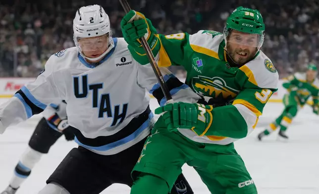 Minnesota Wild right wing Ryan Hartman (38) and Utah Mammoth defenseman Olli Määttä (2) battle for position during the first period of an NHL hockey game Saturday, Oct. 25, 2025, in St. Paul, Minn. (AP Photo/Bailey Hillesheim)