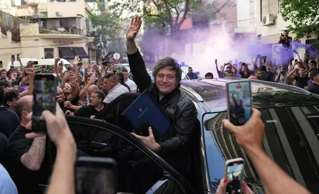 Argentine President Javier Milei waves to supporters upon arriving at a hotel in Rosario, Argentina, Thursday, Oct. 23, 2025. (AP Photo/Rodrigo Abd)