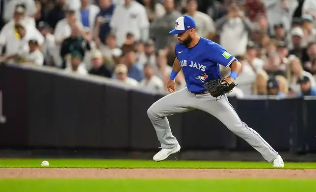 A ground ball hit by New York Yankees Ben Rice gets away from Toronto Blue Jays second baseman Isiah Kiner-Falefa allowing Rice to reach first base safely during the first inning of Game 3 of baseball's American League Division Series, Tuesday, Oct. 7, 2025, in New York. (AP Photo/Yuki Iwamura)