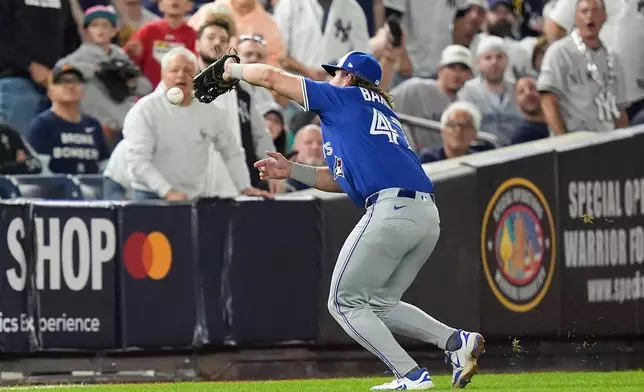 Toronto Blue Jays third baseman Addison Barger (47) drops a fly ball hit by New York Yankees' Austin Wells during the fourth inning of Game 3 of baseball's American League Division Series, Tuesday, Oct. 7, 2025, in New York. (AP Photo/Frank Franklin II)