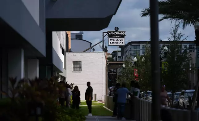 A theater marquee reads "We Love America," alongside the federal government building which houses the Orlando Immigration Court and the Social Security Administration office, in downtown Orlando, Fla., Wednesday, Aug. 20, 2025. (AP Photo/Rebecca Blackwell)