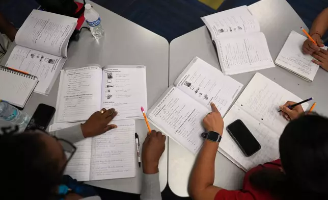 Immigrants trying to learn the English language do a workbook exercise as they participate in ESOL class offered by Catholic Charities of Central Florida, Tuesday, Aug. 19, 2025, in Orlando, Fla. (AP Photo/Rebecca Blackwell)