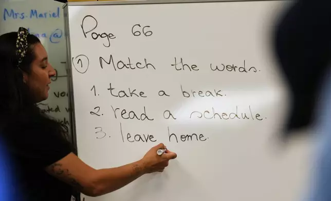 Patricia Otero writes phrases on the board as she teaches a Catholic Charities of Central Florida ESOL class to immigrants trying to learn the English language, Tuesday, Aug. 19, 2025, in Orlando, Fla. (AP Photo/Rebecca Blackwell)