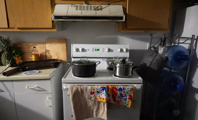 Pots containing food cooked for the family sit on top of the stove in the home of Mexican asylum seeker Blanca, Wednesday, Aug. 20, 2025, in Apopka, Fla. (AP Photo/Rebecca Blackwell)