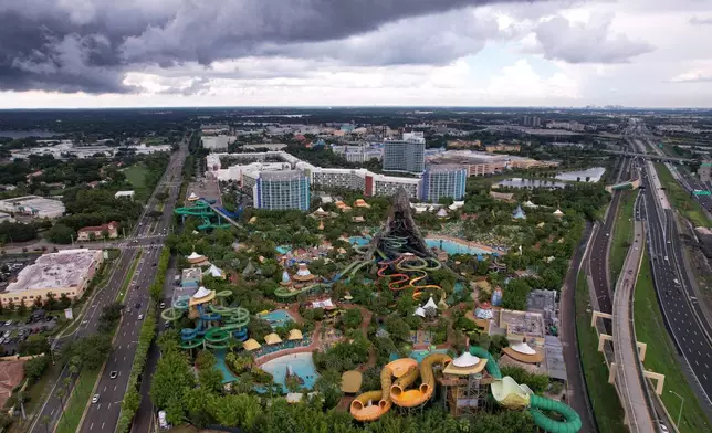 Hotels and highways are seen around Universal Volcano Bay water park, Friday, Aug. 22, 2025, in Orlando, Fla. Migrants who moved to central Florida in recent years say they were drawn by warm temperatures, a large migrant community, and the ease of finding jobs in one of the country's tourism and hospitality hotspots. (AP Photo/Rebecca Blackwell)