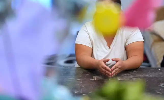 Blanca, a 38-year-old math teacher from Mexico who crossed the border with her three children in 2024 and has applied for asylum, sits at a table inside the family's rented two-bedroom duplex in Apopka, Fla., Wednesday, Aug. 20, 2025. (AP Photo/Rebecca Blackwell)