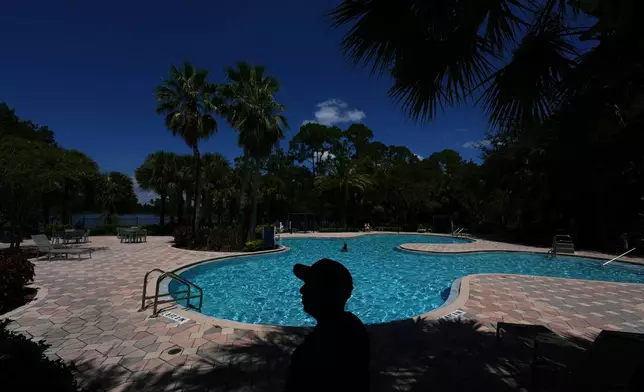 Luis, 30, who fled Venezuela after being an opposition political activist while at university, poses for a picture in the apartment complex where he lives in Orlando, Fla., Tuesday, Aug. 19, 2025. An aspiring entrepreneur with a degree in mechanical engineering, Luis requested asylum in the U.S. and received a work permit which allows him to support himself as an Amazon delivery driver as he goes through the legal asylum process. (AP Photo/Rebecca Blackwell)
