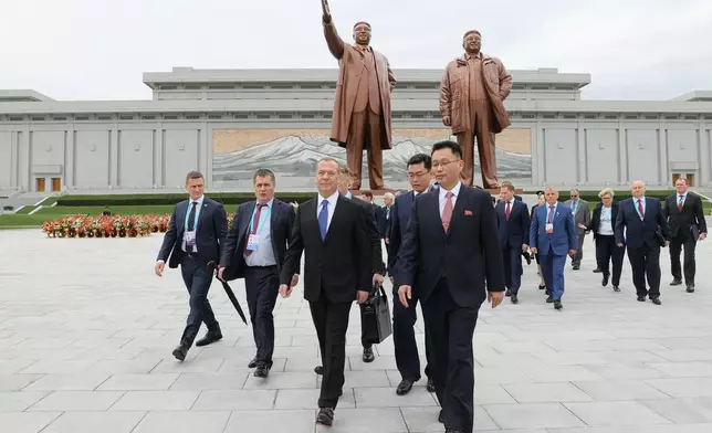 Russian Security Council Deputy Chairman and the head of the United Russia party Dmitry Medvedev, center, leaves after laying flowers to the statues of former North Korean leaders Kim Il Sung and Kim Jong Il on Mansu Hill in Pyongyang, North Korea, on Thursday, Oct. 9, 2025. (Ekaterina Shtukina, Sputnik Pool Photo via AP)