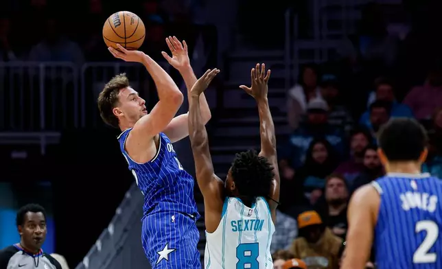 Orlando Magic forward Franz Wagner, left, shoots over Charlotte Hornets guard Collin Sexton (8) during the first half of an NBA basketball game in Charlotte, N.C., Thursday, Oct. 30, 2025. (AP Photo/Nell Redmond)