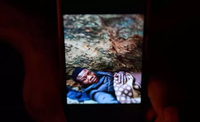 Sudanese shepherd Osam Abdulmumen shows a mobile picture of his migrant journey before arriving in Los Cortijos, central Spain, Tuesday, Oct. 7, 2025. (AP Photo/Bernat Armangue)