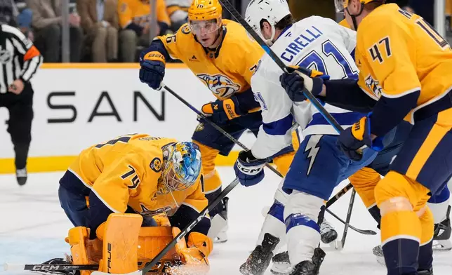 Nashville Predators goaltender Juuse Saros (74) defends the goal against the Tampa Bay Lightning center Anthony Cirelli (71) during the first period of an NHL hockey game Tuesday, Oct. 28, 2025, in Nashville, Tenn. (AP Photo/George Walker IV)