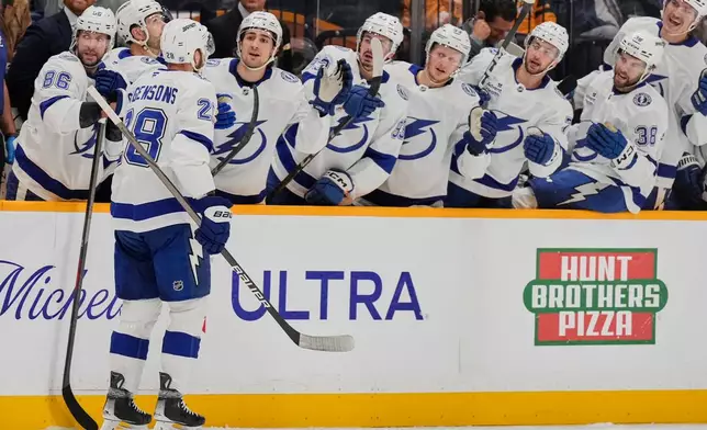Tampa Bay Lightning center Zemgus Girgensons (28) celebrates his goal with teammates during the first period of an NHL hockey game against the Nashville Predators, Tuesday, Oct. 28, 2025, in Nashville, Tenn. (AP Photo/George Walker IV)