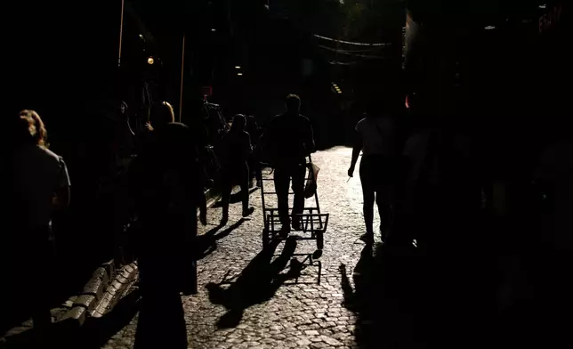 A porter pulls his trolley after unloading goods in the Eminonu commercial area of Istanbul, Turkey, Tuesday, Sept. 23, 2025. (AP Photo/Emrah Gurel)