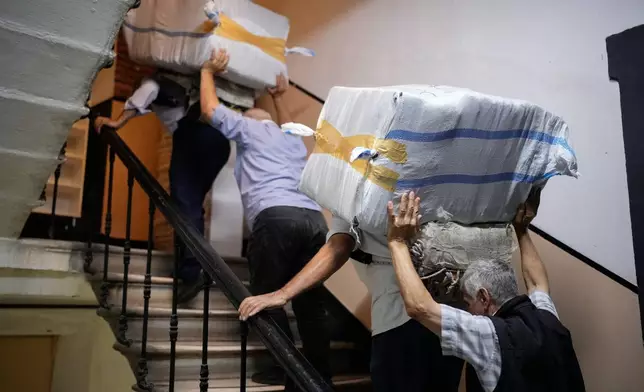 Porters haul loads up the stairway in Istanbul, Turkey, Wednesday, Sept. 24, 2025. (AP Photo/Emrah Gurel)