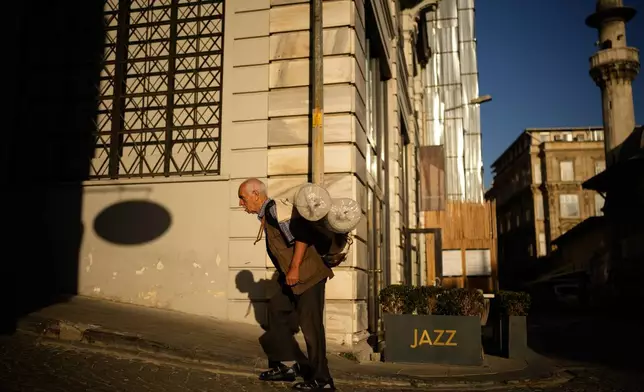 A porter carries a load on his back in Istanbul, Turkey, Wednesday, Sept. 24, 2025. (AP Photo/Emrah Gurel)