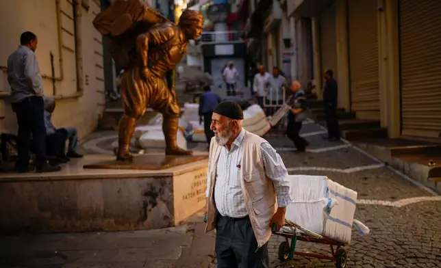 Porters use trolleys to pull loads in Istanbul, Turkey, Wednesday, Sept. 24, 2025. (AP Photo/Emrah Gurel)
