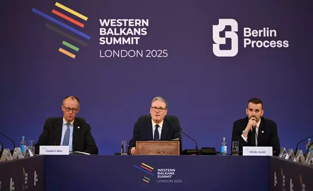 Britain's Prime Minister Keir Starmer, center, flanked by German Chancellor Friedrich Merz, left, and Montenegro's Prime Minister Milojko Spajic, hosts the plenary session of the Western Balkans Summit Western Balkans Summit in London, Wednesday, Oct. 22, 2025. (Chris J Ratcliffe/Pool Photo via AP)