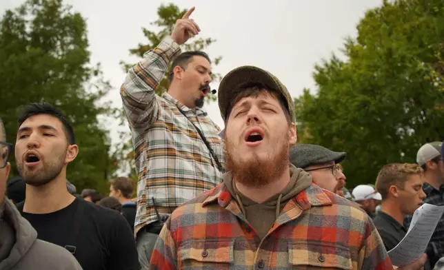 Attendees sing hymns in front of the town hall during Pride Fest in Wake Forest, N.C., on Saturday, Oct. 11, 2025. The LGBTQ+ festival coincided with National Coming Out Day. (AP Photo/Allen G. Breed)