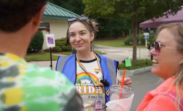 Amanda Cottrill, co-chair of Pride Fest, talks with people on the street in Wake Forest, N.C., on Saturday, Oct. 11, 2025. (AP Photo/Allen G. Breed)