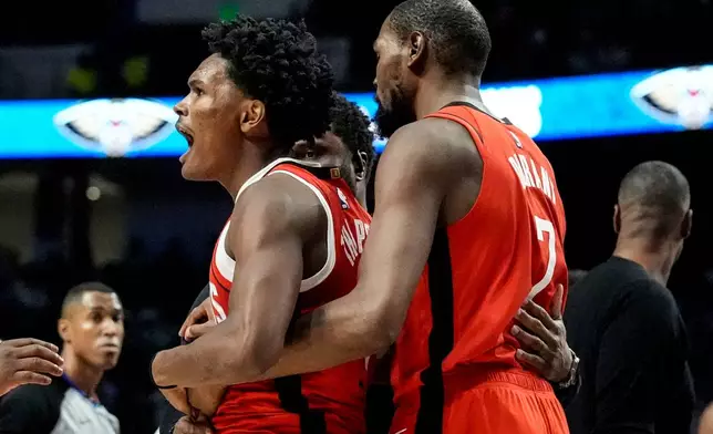 Houston Rockets' Amen Thompson (1) is held by Kevin Durant (7) after a scuffle on the court against New Orleans Pelicans' Jose Alvarado during the first half of an NBA preseason basketball game, Tuesday, Oct. 14, 2025, in Birmingham, Ala. (AP Photo/Mike Stewart)
