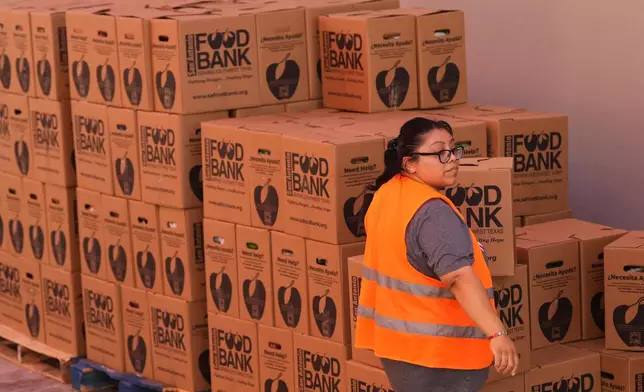 Volunteer Cindy Leiva helps load a vehicle during a food distribution targeting federal employee households affected by the federal shutdown as well as SNAP recipients, Monday, Oct. 27, 2025, in San Antonio. (AP Photo/Eric Gay)