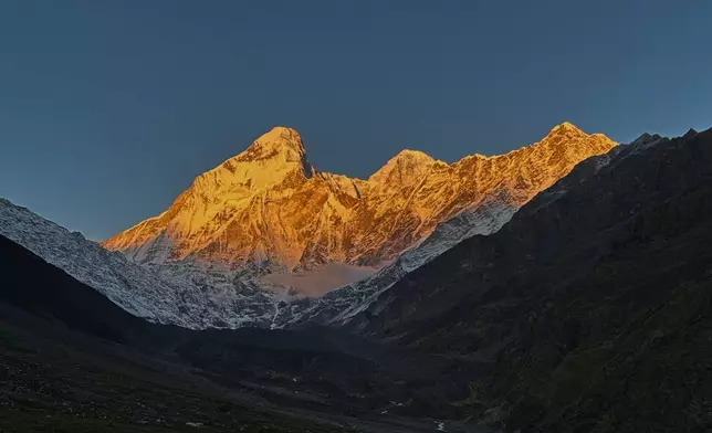 The morning sun illuminates Nanda Devi peak as seen from Nanda Devi base camp, in the northern Indian Himalayan state of Uttarakhand, on Oct. 1, 2025. (AP Photo/Satish Sharma)