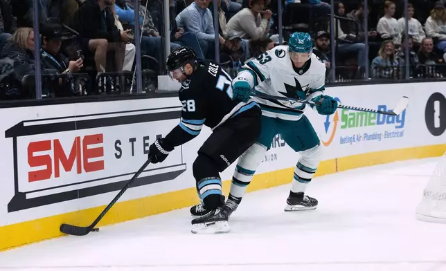 Utah Mammoth defenseman Ian Cole (28) fights for the puck against San Jose Sharks left wing Jeff Skinner (53) during the first period of an NHL hockey game Friday, Oct. 17, 2025, in Salt Lake City. (AP Photo/Melissa Majchrzak)