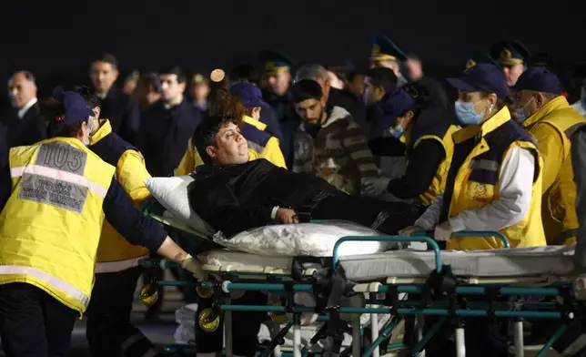 FILE - Injured passengers from an Azerbaijan Airline jet that crashed near Aktau, Kazakhstan, are transported from a medical plane at the Heydar Aliyev International Airport outside Baku, Azerbaijan, on Dec. 26, 2024. (AP Photo, File)