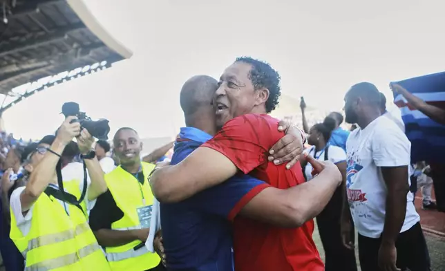 Two men celebrate after Cape Verde defeated Eswatini in a World Cup qualifying soccer match at Estádio Nacional in Praia, Cape Verde, Monday, Oct. 13, 2025, to clinch their qualification for the 2026 World Cup. (AP Photo/Cristiano Barbosa)