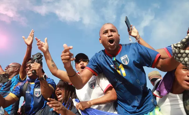 Fans celebrate in the stands after Cape Verde defeated Eswatini in a World Cup qualifying soccer match at Estádio Nacional in Praia, Cape Verde, Monday, Oct. 13, 2025, to clinch their qualification for the 2026 World Cup. (AP Photo/Cristiano Barbosa)