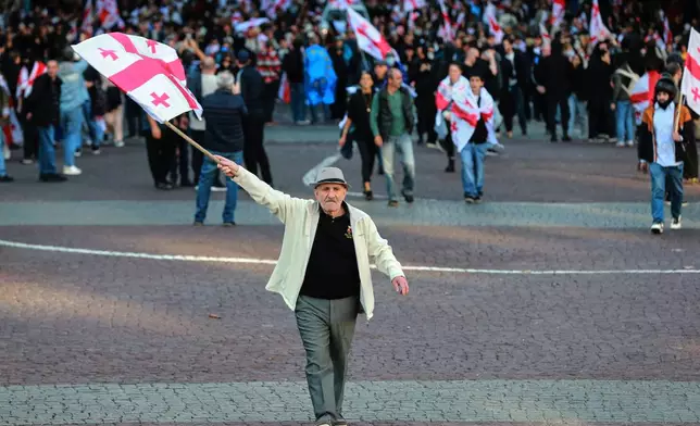 Opposition supporters with Georgian national flags gather in the city center of Tbilisi, Georgia, on Saturday, Oct. 4, 2025, boycotting the municipal elections and call for the release of political opponents. (AP Photo/Zurab Tsertsvadze)