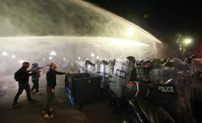 Police use a water cannon to block protesters during an opposition rally in the city center of Tbilisi, Georgia, on Saturday, Oct. 4, 2025, boycotting the municipal elections and call for the release of political opponents. (AP Photo/Zurab Tsertsvadze)