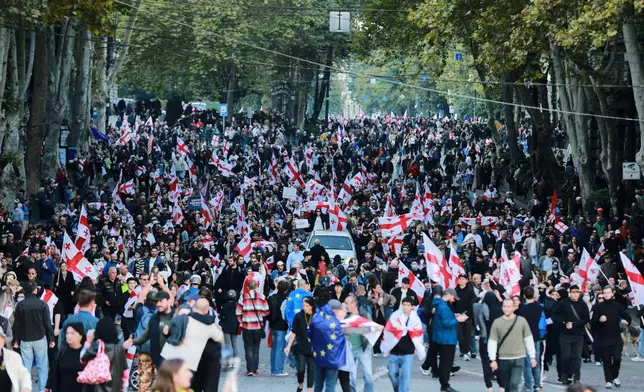 Opposition supporters with Georgian national flags gather in the city center of Tbilisi, Georgia, on Saturday, Oct. 4, 2025, boycotting the municipal elections and call for the release of political opponents. (AP Photo/Zurab Tsertsvadze)