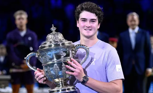 Brazil's Joao Fonseca poses with the trophy after winning the final match against Spain's Alejandro Davidovich Fokina at the Swiss Indoors tennis tournament in Basel, Switzerland, Sunday, Oct. 26, 2025. (Georgios Kefalas/Keystone via AP)