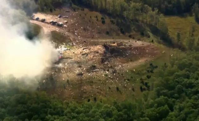 Smoke fills the air as debris covers the ground and vehicles after a powerful blast ripped through a military explosives manufacturing plant in Hickman County, Tenn., on Friday, Oct. 10, 2025. (WTVF-TV via AP)