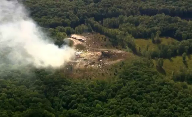 Smoke fills the air as debris covers the ground and vehicles after a powerful blast ripped through a military explosives manufacturing plant in Hickman County, Tenn., on Friday, Oct. 10, 2025. (WTVF-TV via AP)