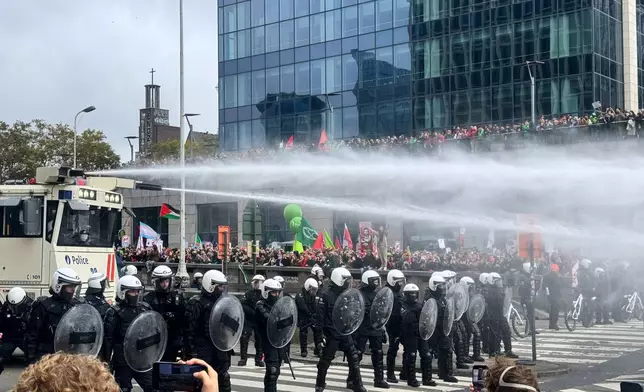 Police use a water cannon against protestors during a demonstration and general strike in Brussels, Tuesday, Oct. 14, 2025. (AP Photo/Sylvain Plazy)