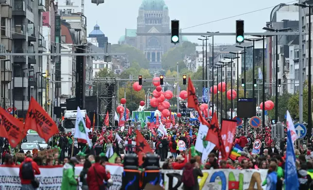People march with signs crossed out with the number 67, referring to pension age, during a demonstration and general strike in Brussels, Tuesday, Oct. 14, 2025. (AP Photo/Harry Nakos)