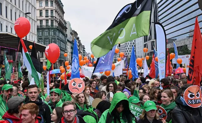 People march with signs and balloons during a demonstration and general strike in Brussels, Tuesday, Oct. 14, 2025. (AP Photo/Harry Nakos)