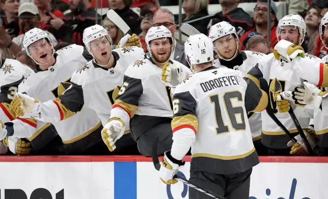 Vegas Golden Knights right wing Pavel Dorofeyev (16) celebrates his goal with teammates after he scored against the Carolina Hurricanes during the first period of an NHL hockey game Tuesday, Oct. 28, 2025, in Raleigh, N.C. (AP Photo/Chris Seward)
