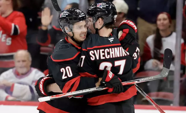 Carolina Hurricanes right wing Andrei Svechnikov (37) celebrates his goal with center Sebastian Aho (20) after he scored against the Vegas Golden Knights during the first period of an NHL hockey game Tuesday, Oct. 28, 2025, in Raleigh, N.C. (AP Photo/Chris Seward)